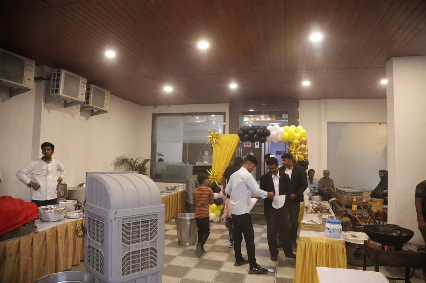 Guests and hotel staff gathered beside buffet counters in the banquet hall