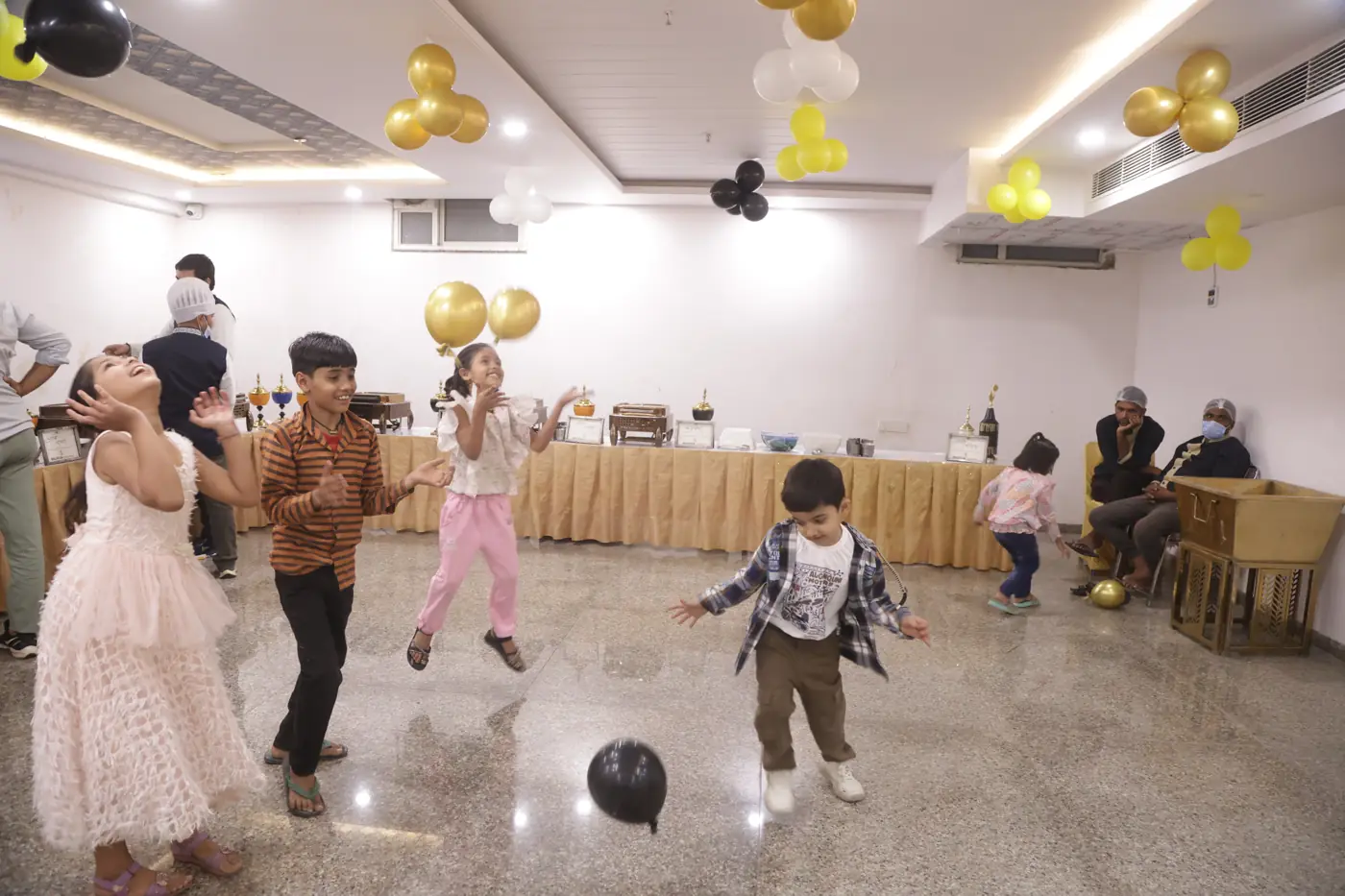 Children running and playing in the decorated banquet hall