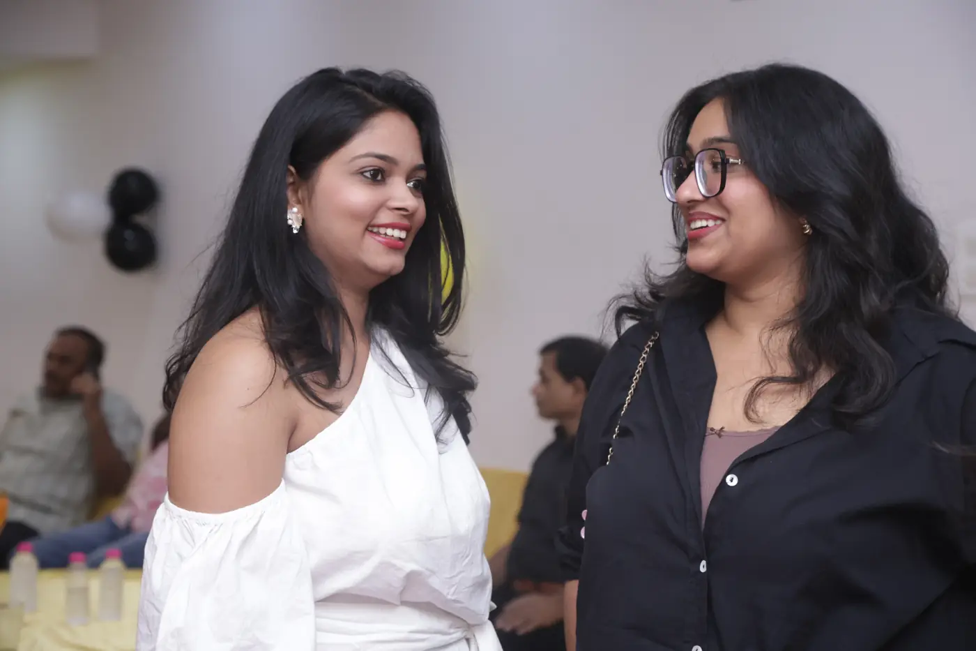 Two guests chatting and smiling at the celebration