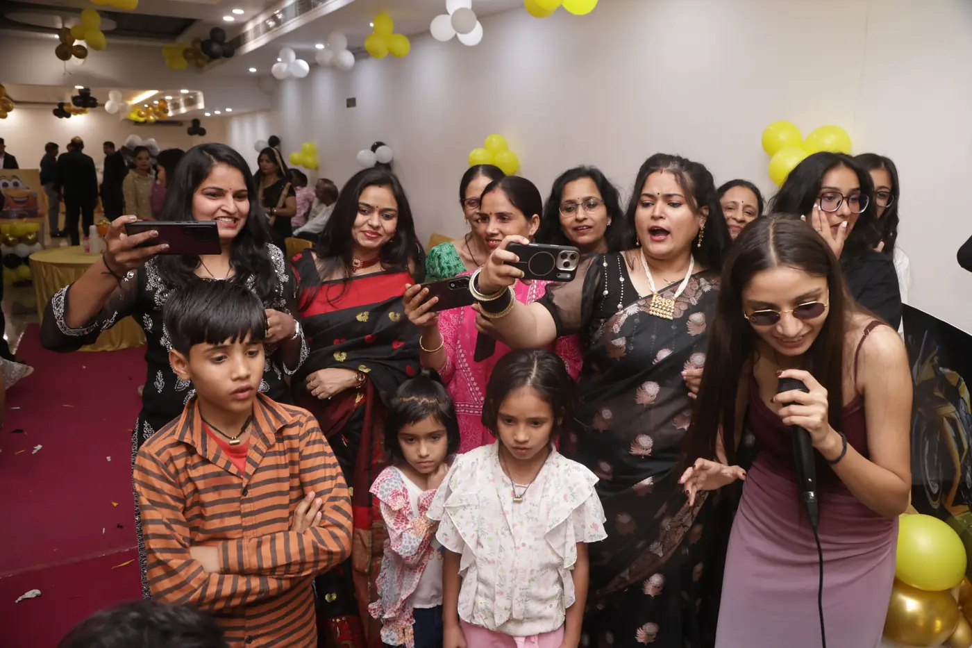 A crowd of guests and children gathered around a singer