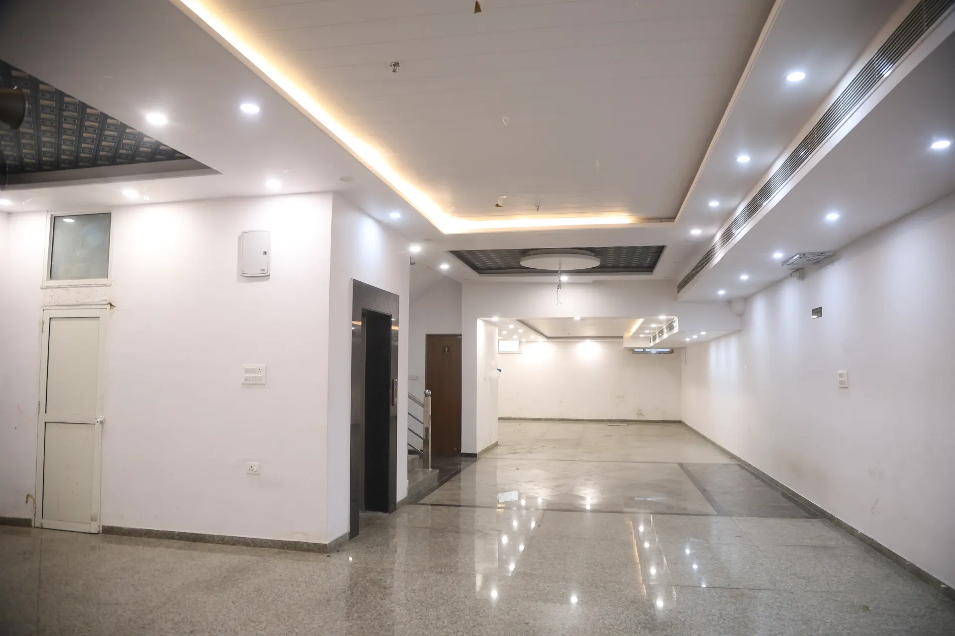 Wide view of the empty banquet hall with polished stone flooring