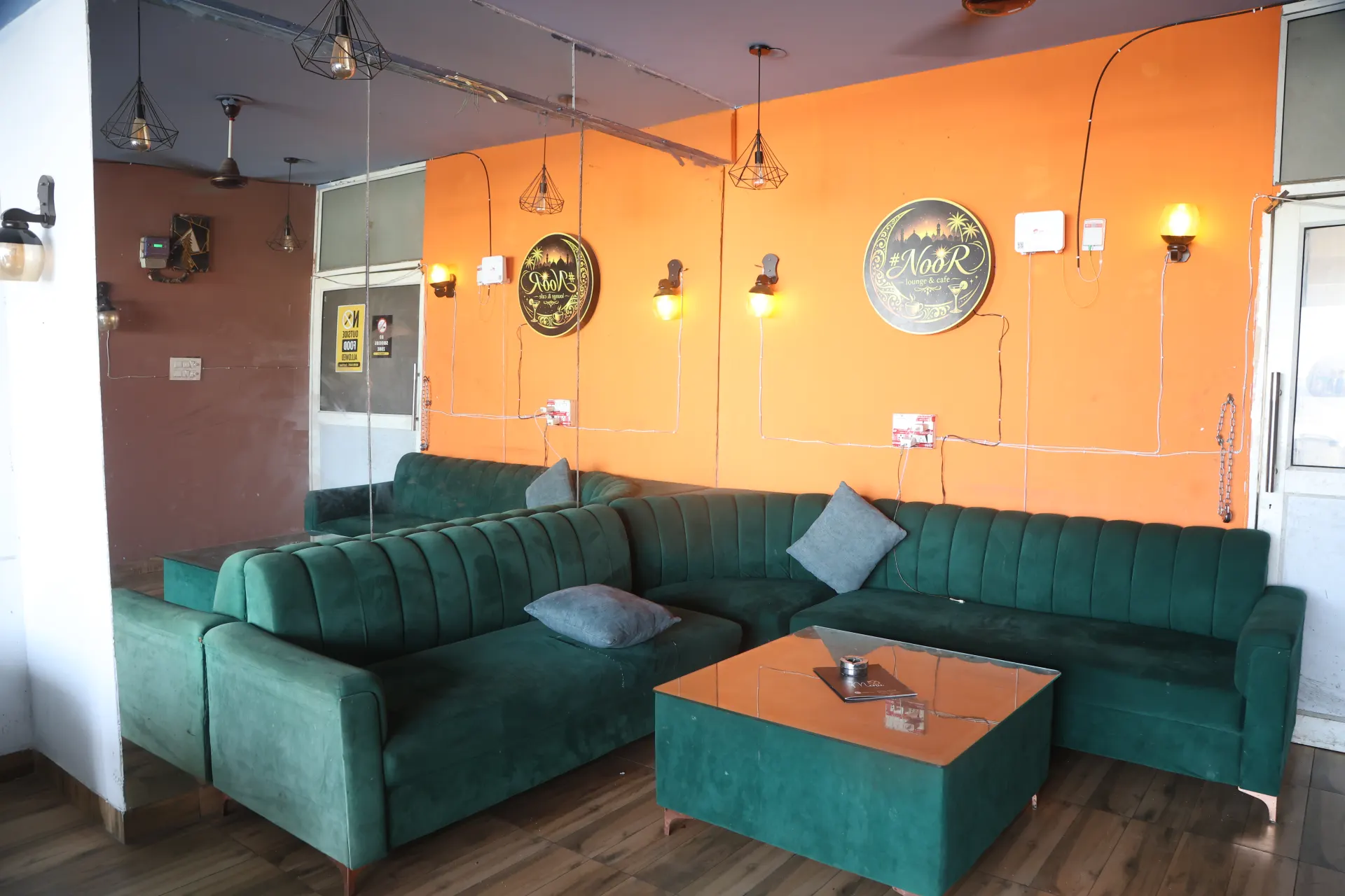 Teal sofas and orange feature wall in the rooftop lounge