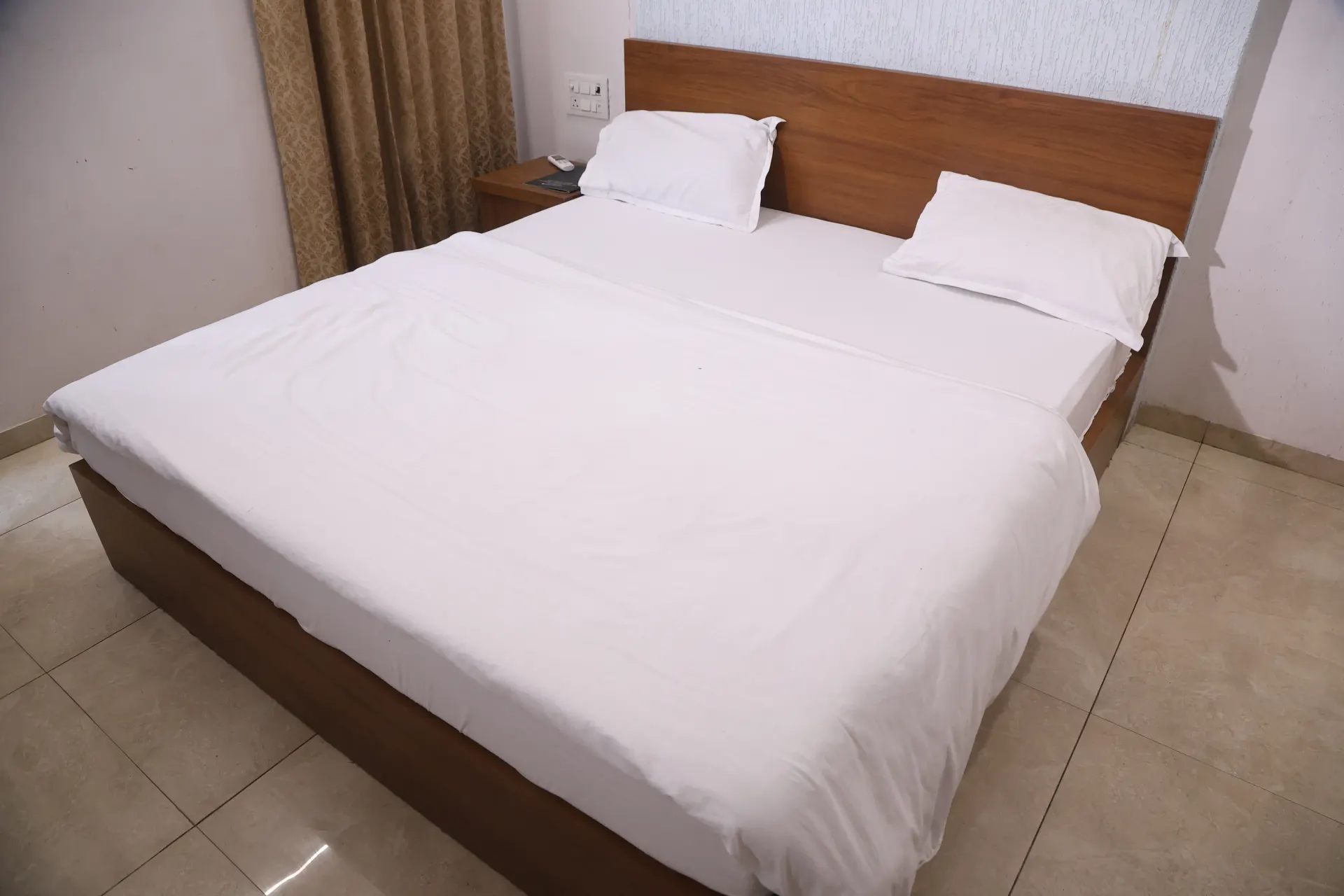 Air-conditioned guest room with a white bed
